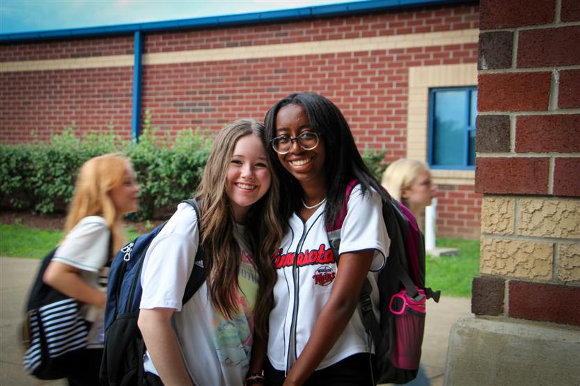 Two students smile